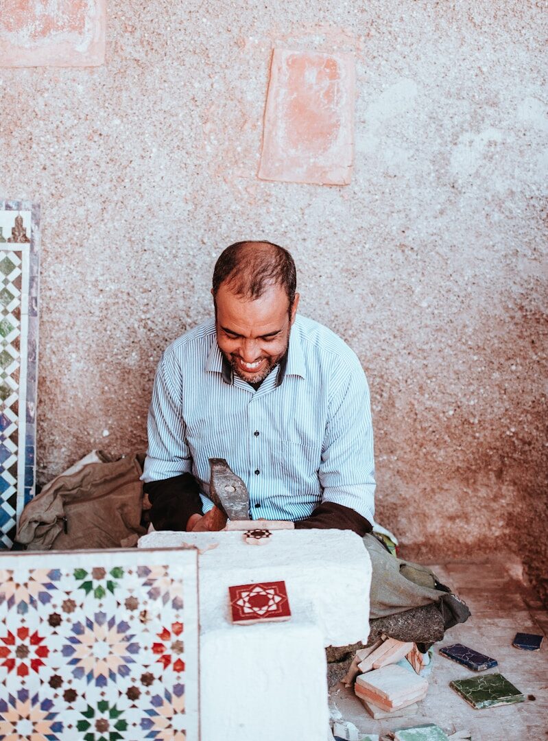 man smiling sitting on floor during daytime
